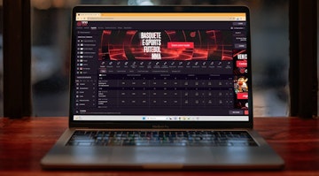 Mockup de um laptop em cima de uma mesa mostrando a pagina inicial de esportes da Onabet